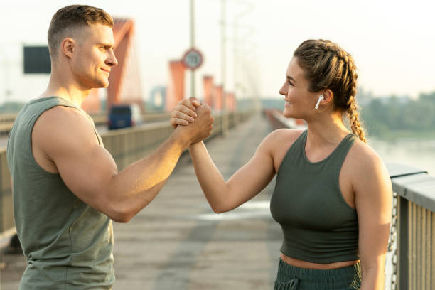 Athletic couple making handshake during fitness workout on city street