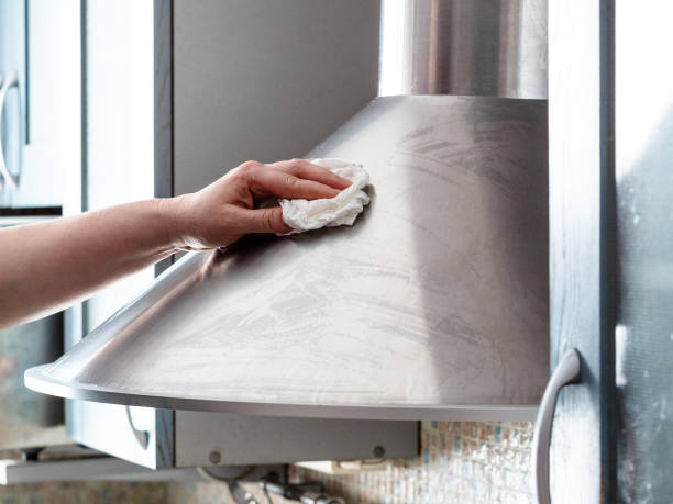 female hand cleans stainless steel kitchen hood female hand cleans stainless steel kitchen hood at home kitchen hood stock pictures, royalty-free photos & images