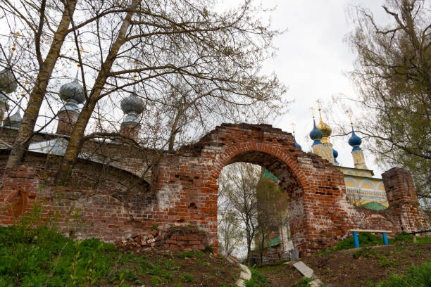 Old red brick wall gate to the church in cloudy spring day
