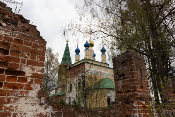 istock Old red brick wall gate to the church in cloudy spring day 1316800905