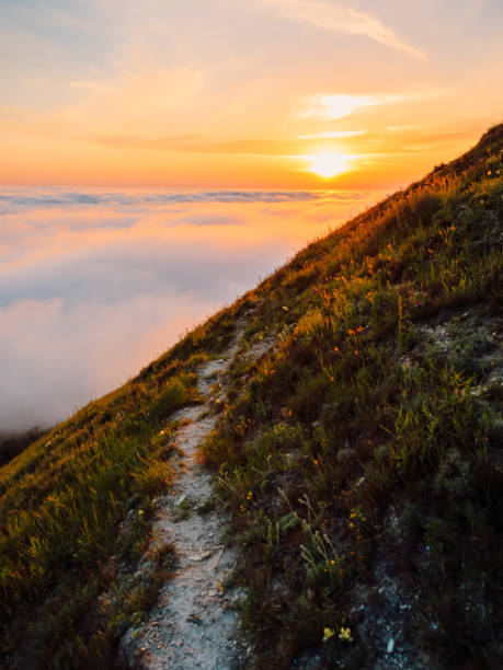istock Warm sunset, clouds, fog and mountains with trail 1316803721