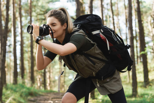 istock Hiker taking photos using  modern mirrorless camera in green forest 1316803856