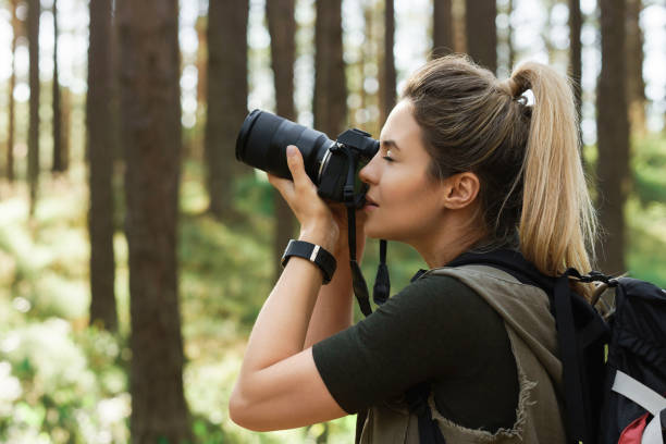 istock Hiker taking photos using  modern mirrorless camera in green forest 1316803927