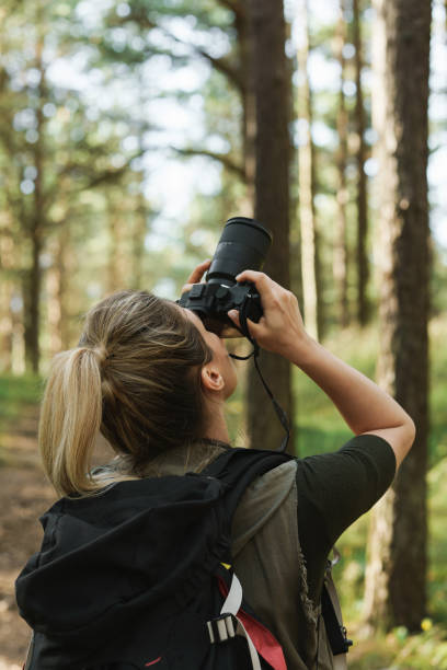 istock Hiker taking photos using  modern mirrorless camera in green forest 1316803987