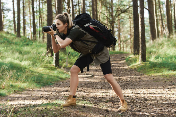 istock Hiker taking photos using  modern mirrorless camera in green forest 1316804162