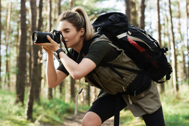 istock Hiker taking photos using  modern mirrorless camera in green forest 1316804361