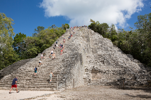 Coba, Mexico - January 31, 2018: Tourists climb Nohoch Mul, the tallest of all Mayan pyramids at Coba, Quintana Roo, Yucatan peninsula, Mexico