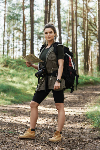 istock Female hiker with big backpack using map for orienteering in the forest 1316805250
