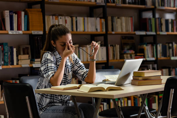 istock Young female student study in the library using laptop for researching online. 1316805298