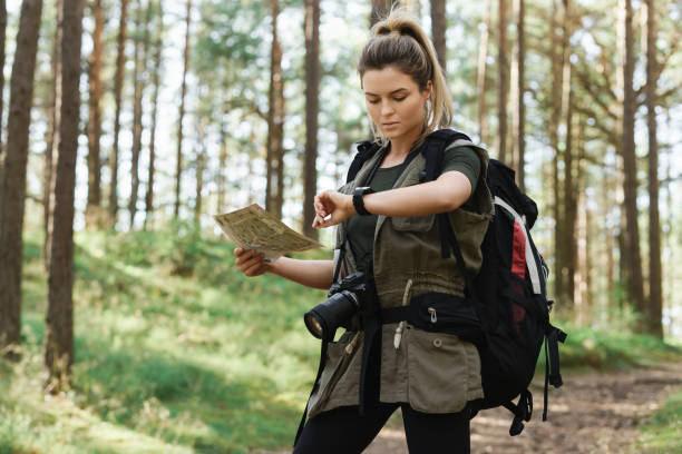 istock Female hiker with big backpack using map for orienteering in the forest 1316805360