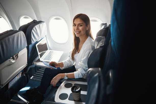 istock Happy lady in the airplane with modern devices 1316805837