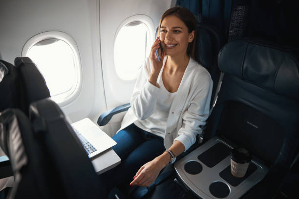 istock Mirthful lady talking on the phone while being in airplane 1316805844