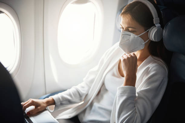 현대 노트북을 사용하여 비행기의 진정 여성 승객 - pollution mask audio 뉴스 사진 이미지