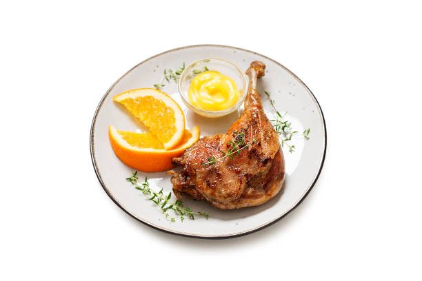 Duck leg confit served with potato chips Duck leg confit served with potato chips and mustard sauce .Traditional french cuisine. isolated on white background confit stock pictures, royalty-free photos & images