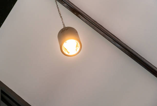 modern pendant light with vintage light bulb, wooden wall on the background