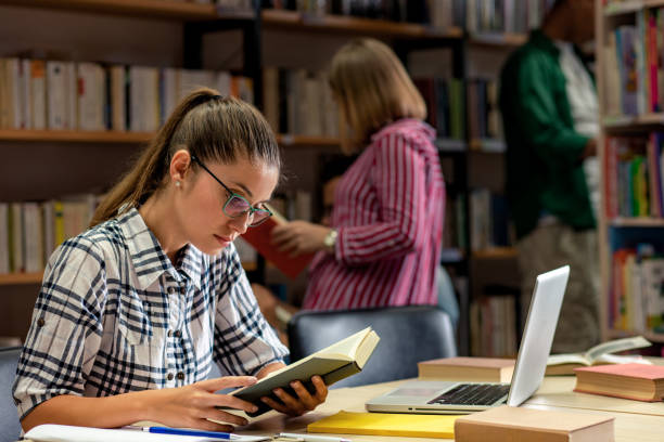 istock Young female student study in the library using laptop for researching online. 1316808196