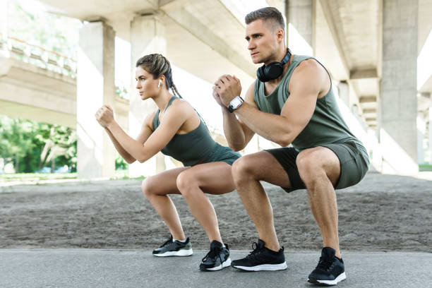 istock Athletic couple doing squats during street workout 1316808236