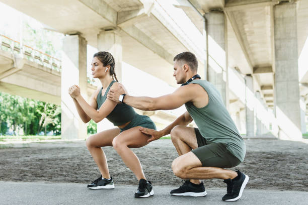 istock Athletic couple doing squats during street workout 1316808291