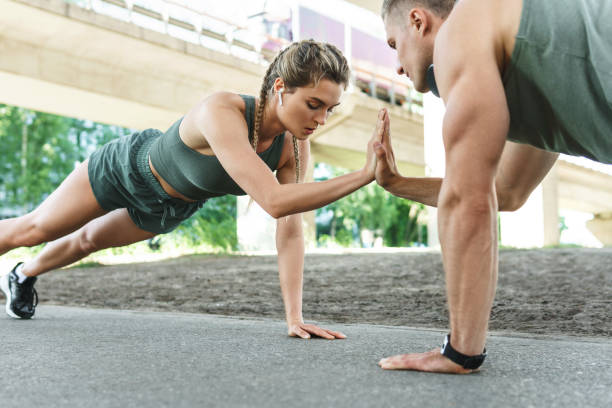 casal atlético e treinamento fitness ao ar livre. homem e mulher fazendo exercícios de flexões. - crossfit exercising sports training outdoors - fotografias e filmes do acervo