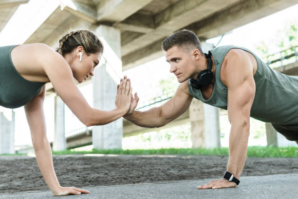 casal atlético e treinamento fitness ao ar livre. homem e mulher fazendo exercícios de flexões. - crossfit exercising sports training outdoors - fotografias e filmes do acervo