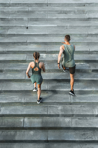 Young sportive couple during workout stair running outdoors