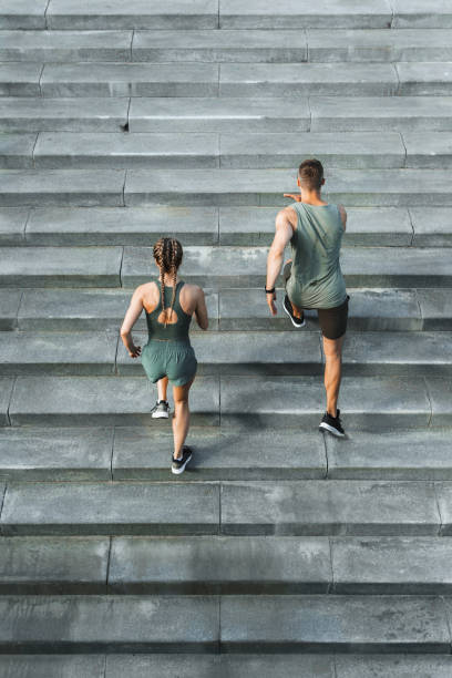 Sportive couple during workout stair running outdoors Young sportive couple during workout stair running outdoors fitness trainer stock pictures, royalty-free photos & images