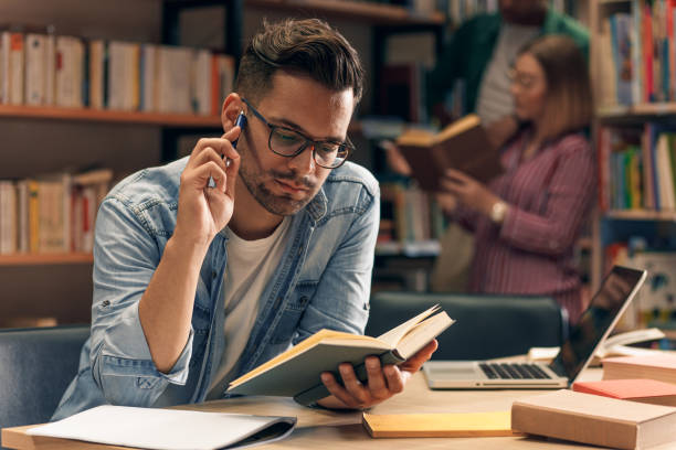 istock Portrait of young student sitting in library studying. 1316808543