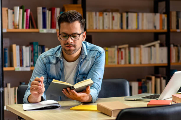 istock Portrait of young student sitting in library studying. 1316808599
