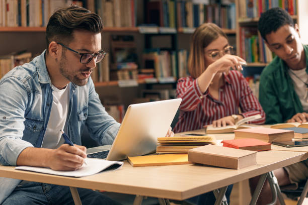 istock Portrait of young student sitting in library studying. 1316808675