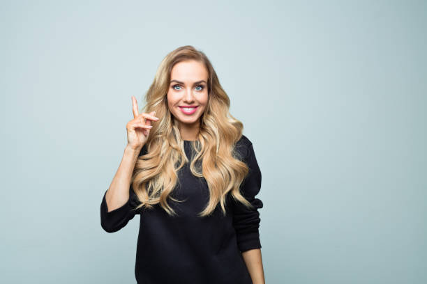 istock Happy young woman pointing at copy space 1316808898
