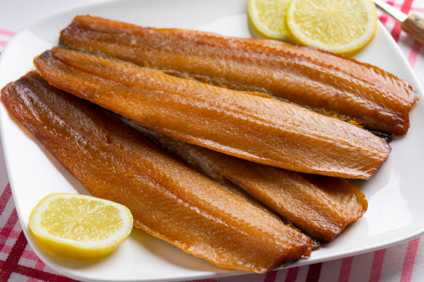 Plate with pair of kippers, smoked herring Plate with a pair of kippers, fillet smoked herring,  for breakfast or lunch kipper stock pictures, royalty-free photos & images