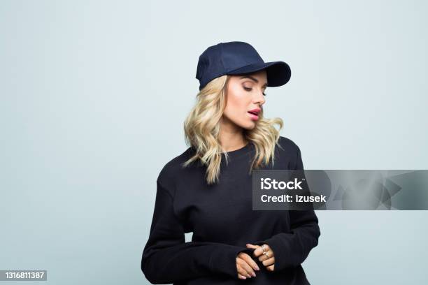 Portrait Of Pensive Young Woman Stock Photo - Download Image Now - Women, Baseball Cap, Blond Hair