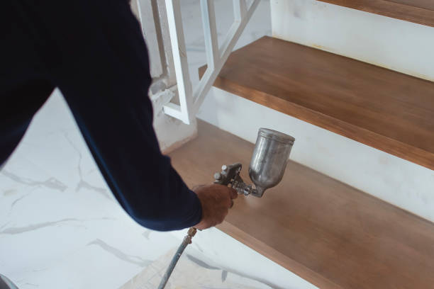istock A construction worker applies varnish on the stairs. Using an airbrush for the application. Renovation or finishing works. 1316812942
