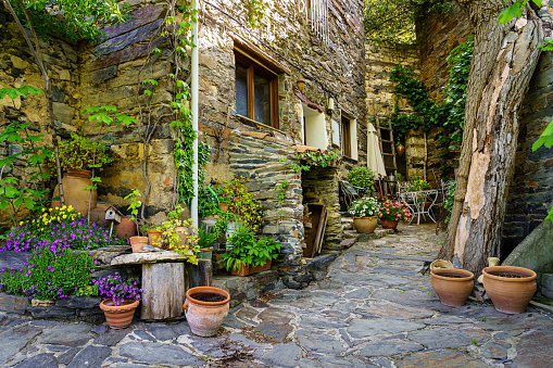 Corner between old town houses with flowerpots, flowers and assorted country items. Patones de Arriba Madrid.