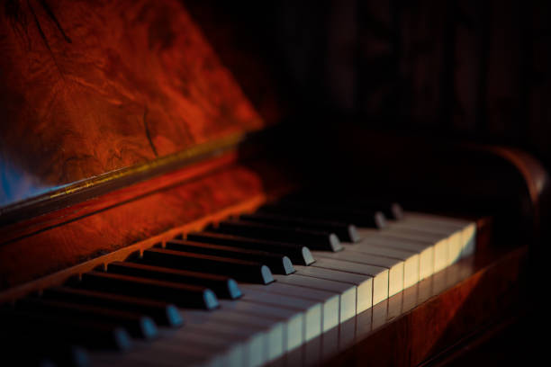 istock Vintage mahogany upright piano, with selective focus in sunlight 1316815893