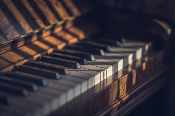 istock Old mahogany upright piano keys, with selective focus in sunlight 1316816522