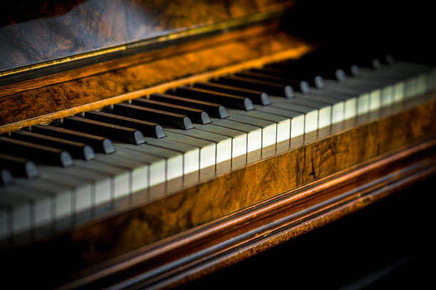istock Old mahogany upright piano keys, with selective focus in sunlight 1316816581