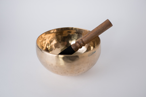 Tibetan Meditation Singing Bowl and wooden mallet with white background
