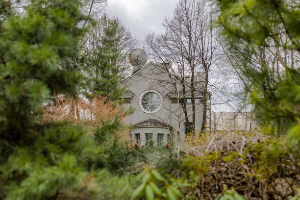 istock Gray stone building with a round window among the trees 1316817836