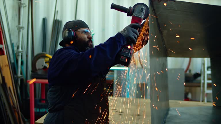 Metal Worker Using Angle Grinder on a Range Hood