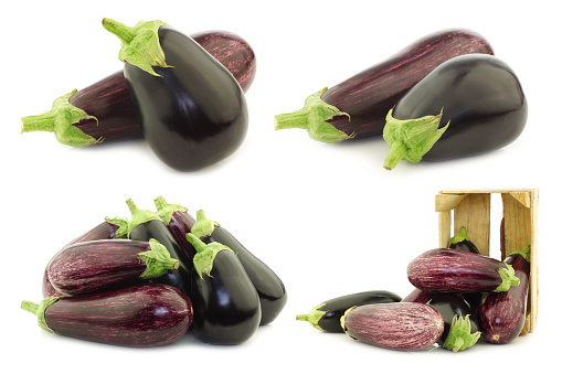 mixed aubergines and some in a wooden crate  on a white background