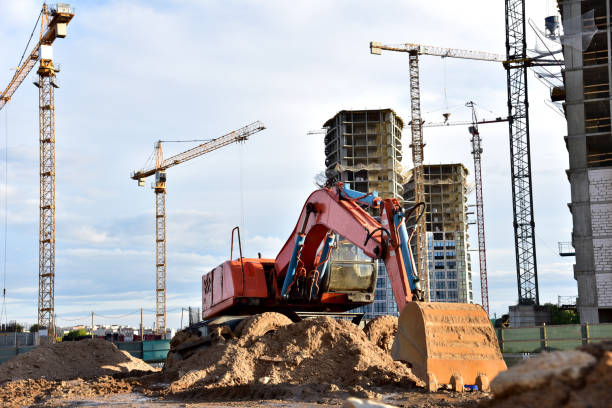 istock Excavator on earthmorks at construction site. Backhoe dig ground for the construction of foundation and laying sewer pipes district heating 1316825437