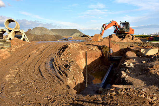 istock Excavator dig the trenches at a construction site. Trench for laying external sewer pipes. Sewage drainage system for a multi-story building 1316825442