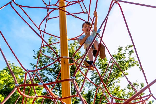 istock Little boy playing at the playground climbing a big rope net 1316828027