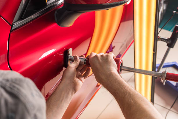 The technician removes dents on the car using the method without painting. PDR. Car body repair. The technician removes dents on the car using the method without painting. PDR. Car body repair. High quality photo arm hammer stock pictures, royalty-free photos & images