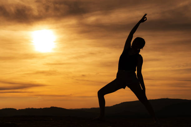 istock woman silhouette exercising at sunset 1316830609