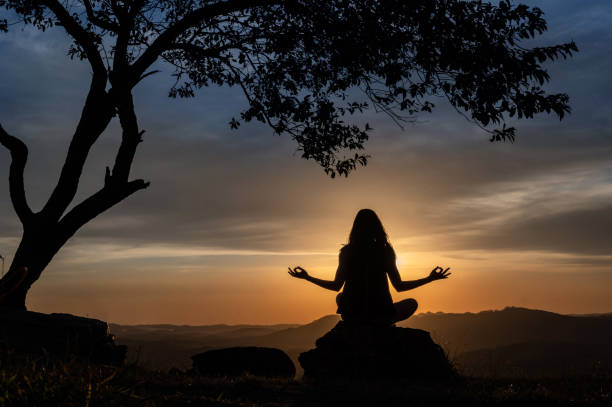 istock woman silhouette doing yoga with a beautiful sunset 1316831128