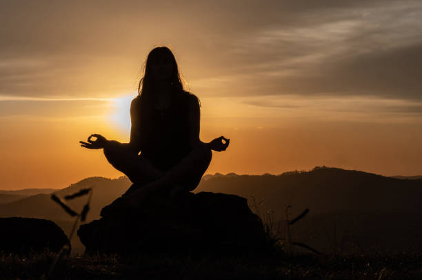 istock woman silhouette doing yoga with a beautiful sunset 1316831193