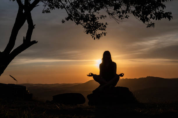 istock woman silhouette doing yoga with a beautiful sunset 1316831218