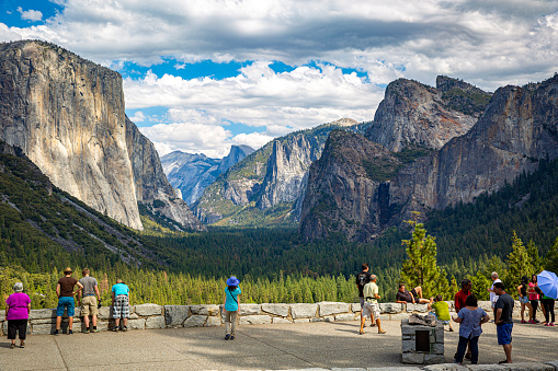 Yosemite National Park. Valley, Tunnel View.  Tourists taking pictures, posing. Coach,bus stop.  roadside.  Car park. El Capitan, Half Dome, and Bridalveil Fall. Yosemite,California. USA